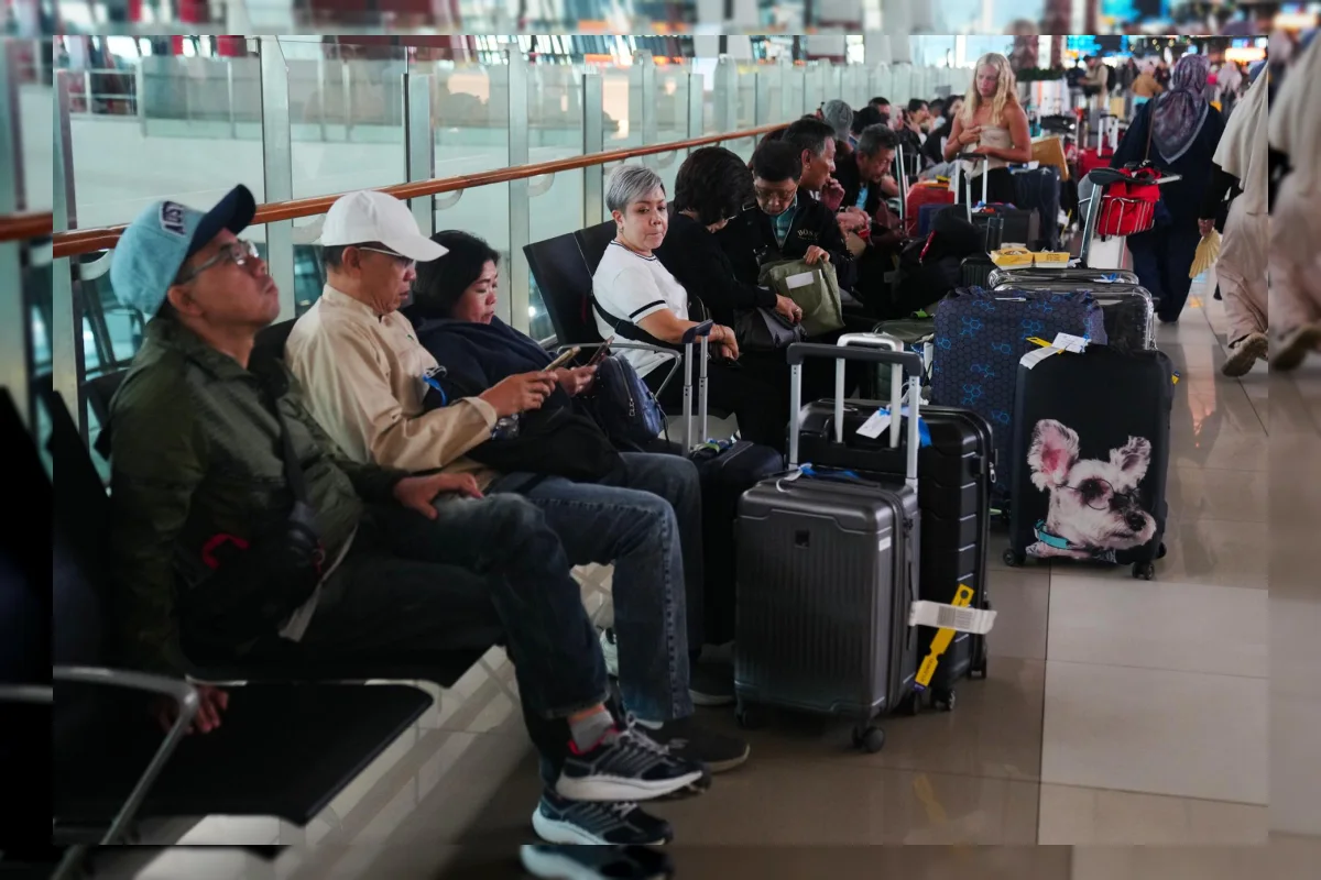 Penumpang melihat papan informasi penerbangan yang dibatalkan di Bandara Soekarno-Hatta akibat letusan Anak Krakatau